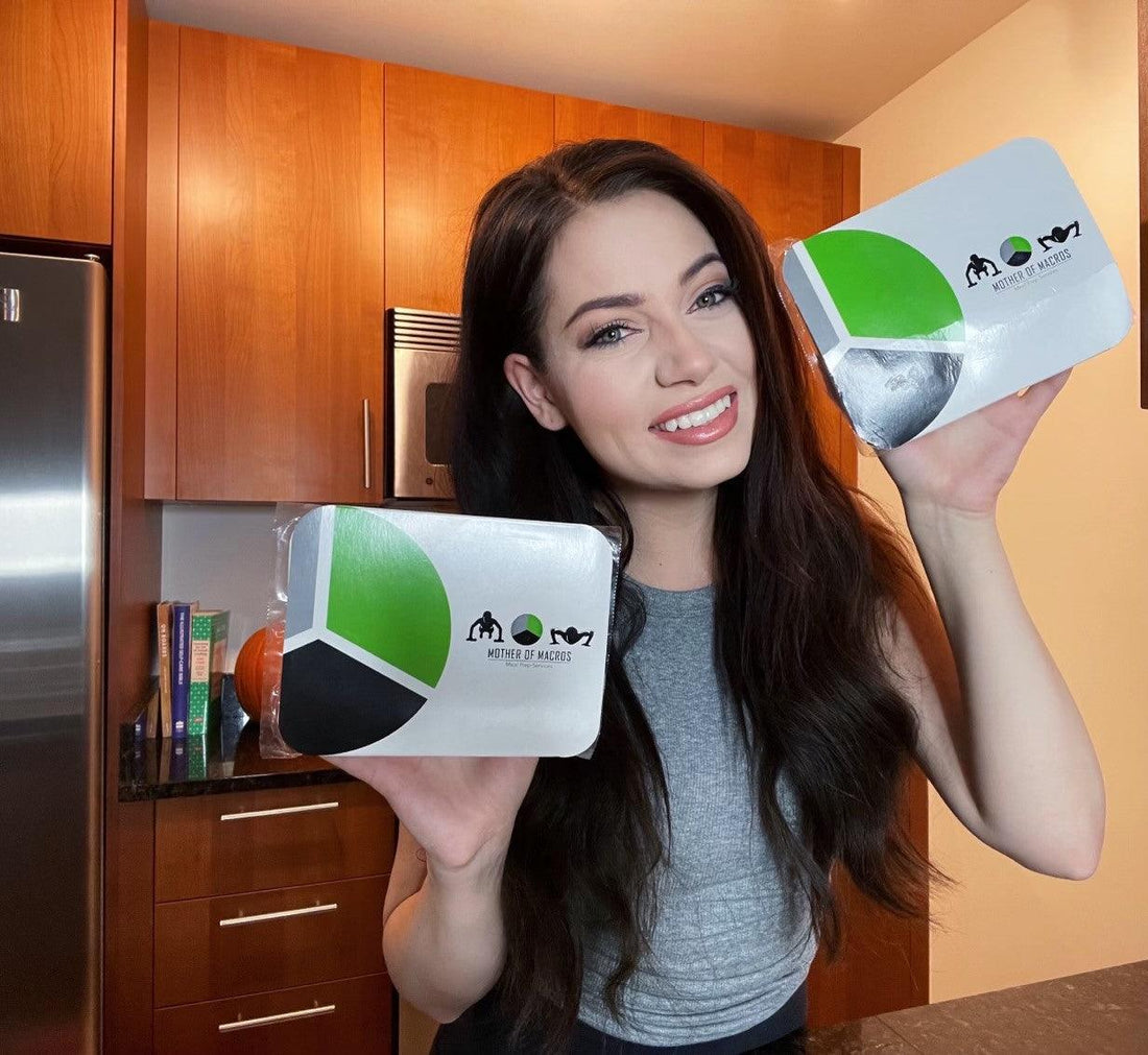 Smiling woman holding meal prep containers in a modern kitchen, promoting healthy meal prep services.